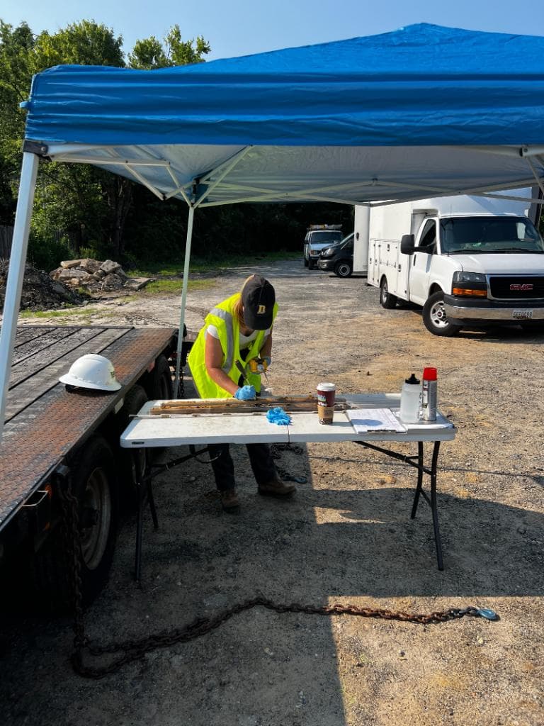 Environmental technician examining soil core samples at a field station