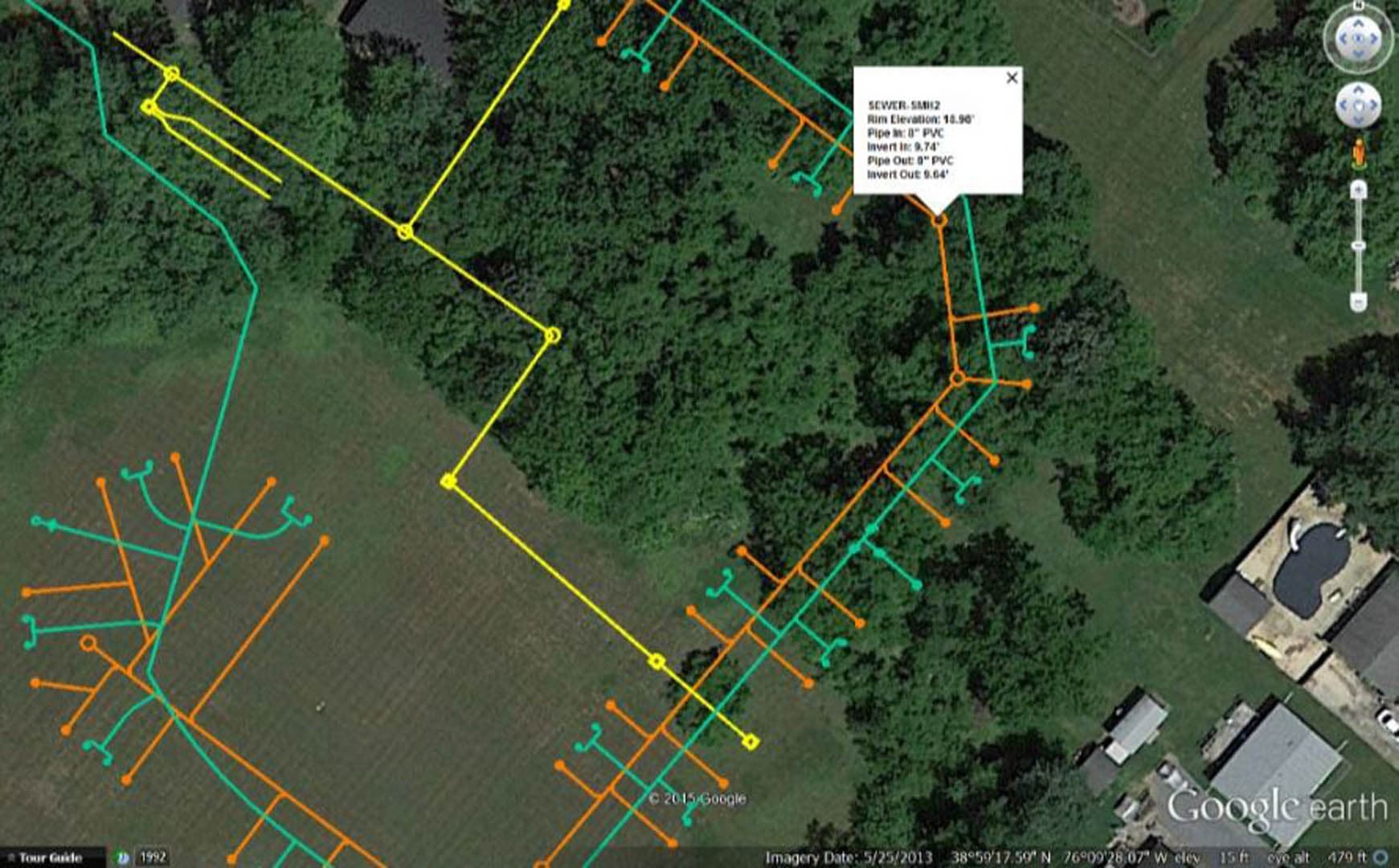 GIS utility mapping of a rural sewer network in Google Earth, showing branching lateral and main sewer lines color-coded over fields and tree cover